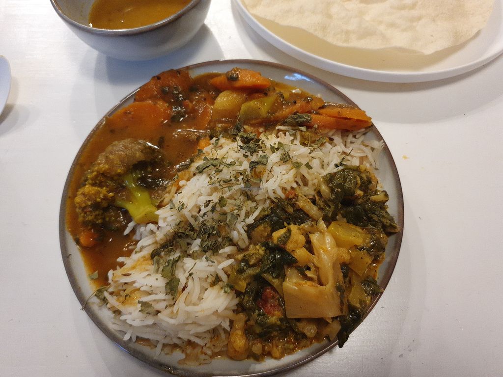 A thali plate with rice, curry and papadum