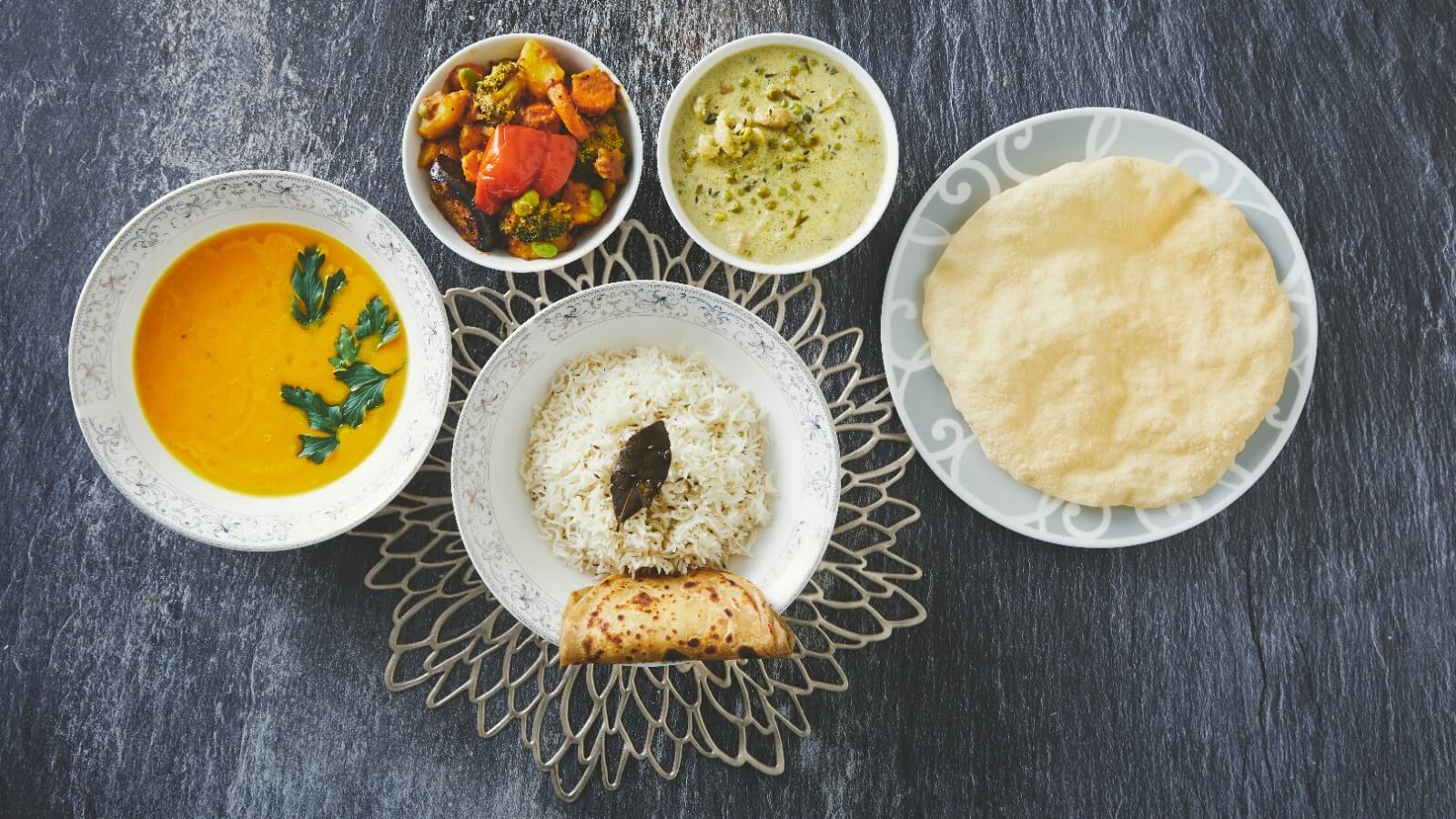 A thali set with dal, rice, curry and bread