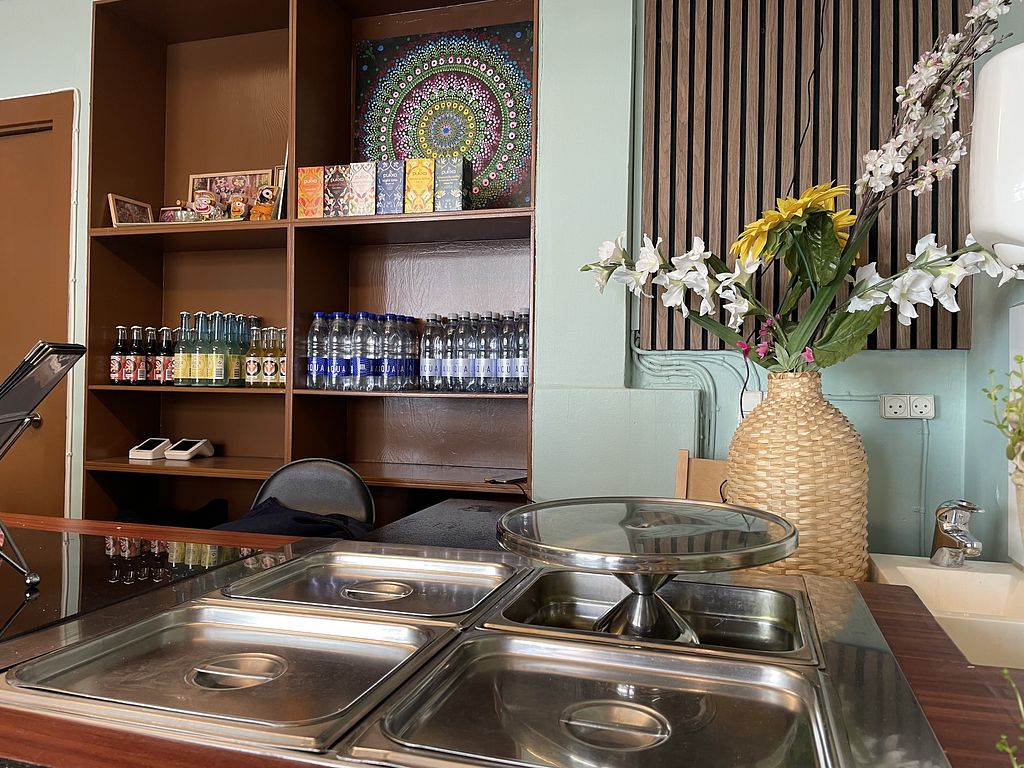 Shelving with drinks, spices and a mandala artwork